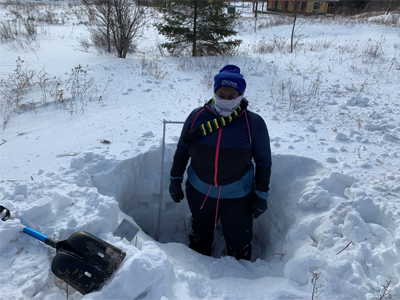 student in snow pit