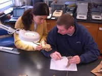 Elena, visiting scholar from Ecuador, shows Leland how to count annual growth rings.