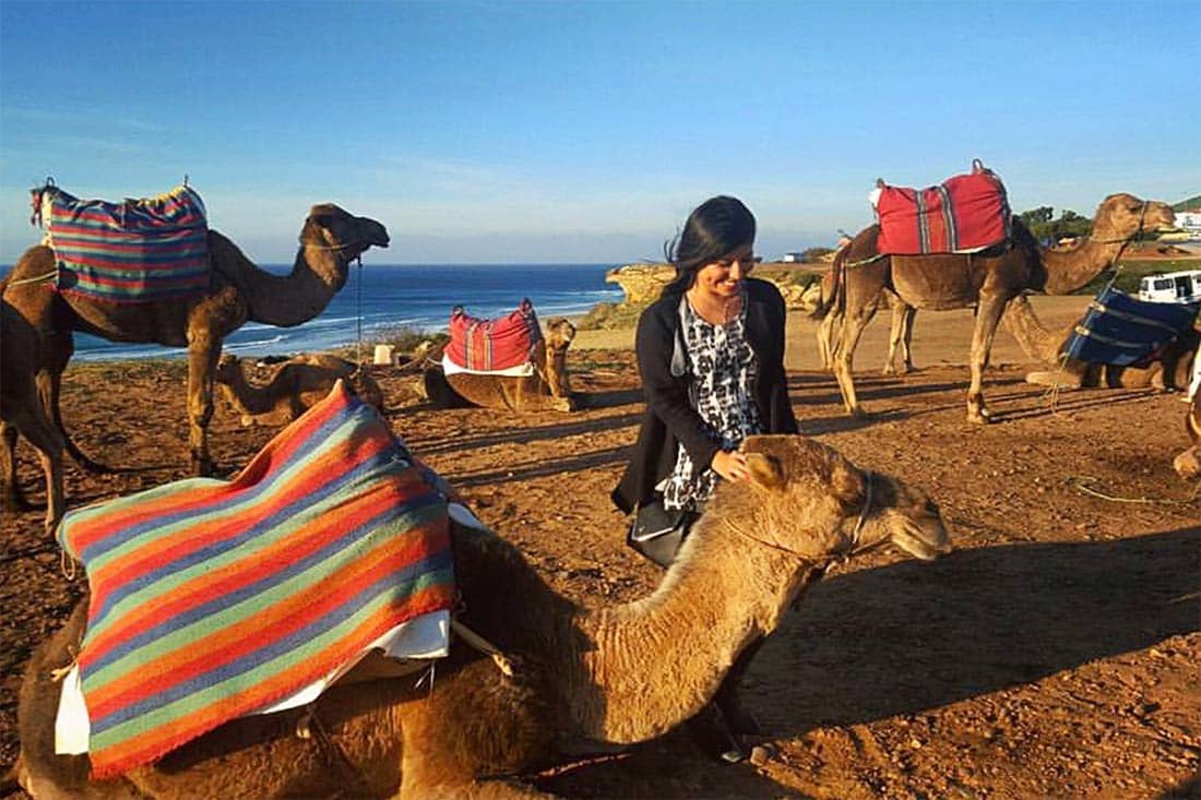Salma Gomez '16 greets a camel in Morocco during one of her five study abroad excursions while a business management student at UTSA.