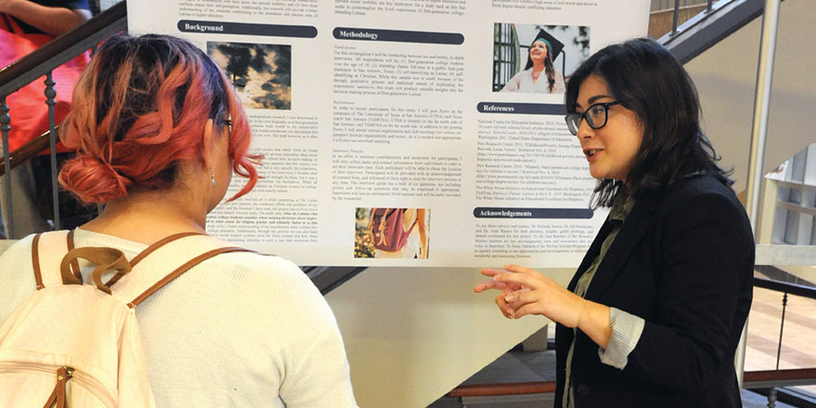 Amanda (right) discusses her research with a student
