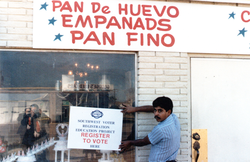 A Southwest Voter Registration Education Project volunteer posts a notice about one of the organization’s upcoming voter registration drives