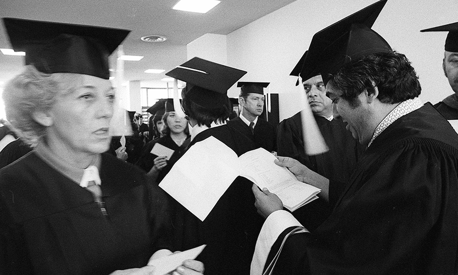 Marjorie Gilbert and Raul Gonzalez make last-minute checks with other graduating students prior to commencement.