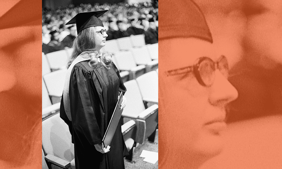 First graduating student Susan Bolado watches the rest of the commencement ceremonies with her diploma in hand.