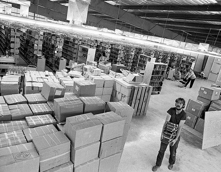 Dave Meyer grabs a stack of labeled, sorted books for the shelves set up in UTSA’s gym.