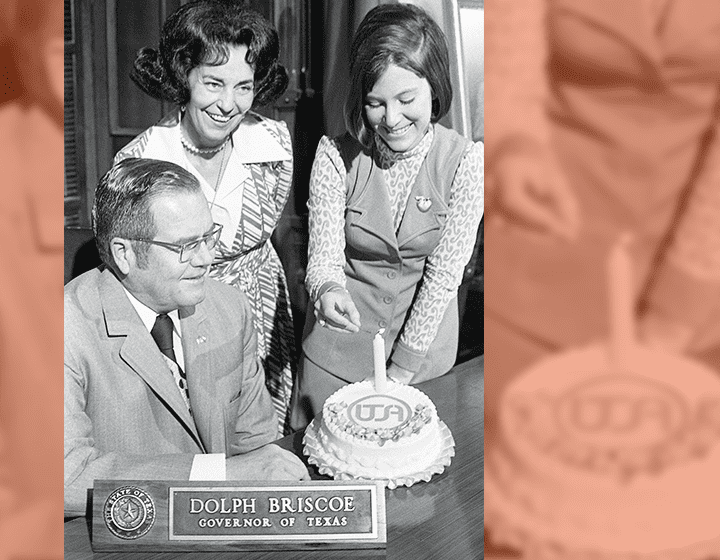 Tholen lights a candle to celebrate UTSA’s first birthday in the Austin capitol office of Gov. Dolph Briscoe with Janey Briscoe.