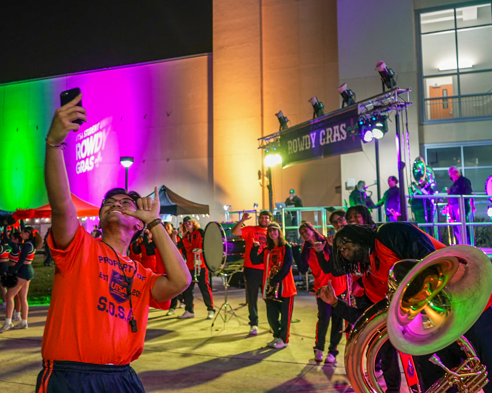 A member of the SOSA Band takes a selfie in front of other bandmembers