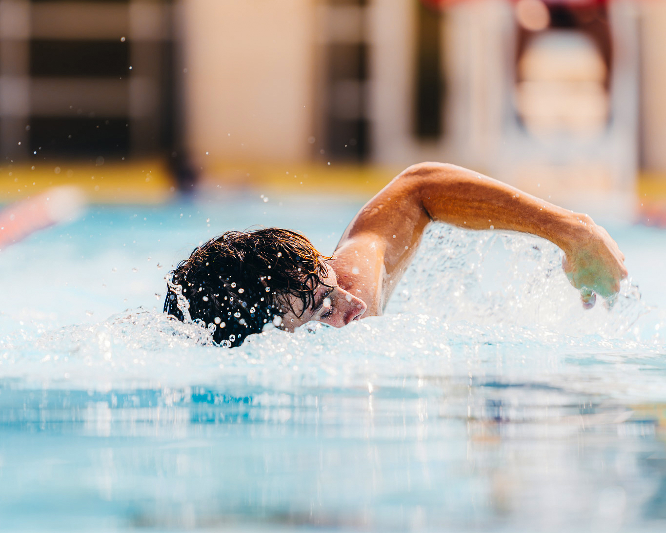 Students performing a long arm swimming stroke in an individual swim lane.