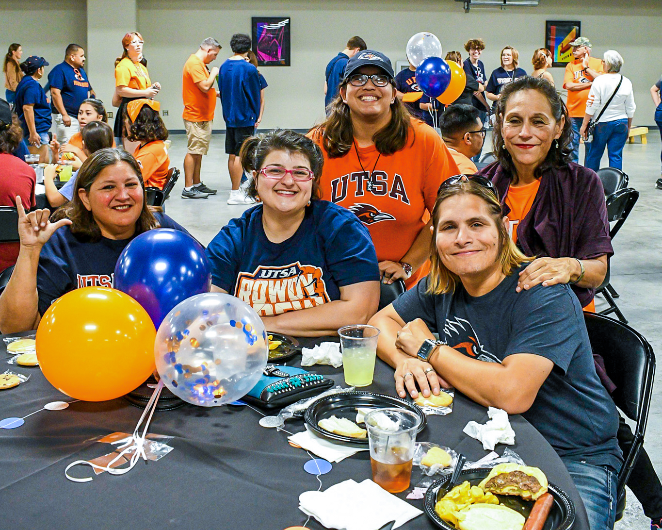five students at a table posing for a photo filling our surveys