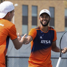 Two student tennis players shaking hands on the field