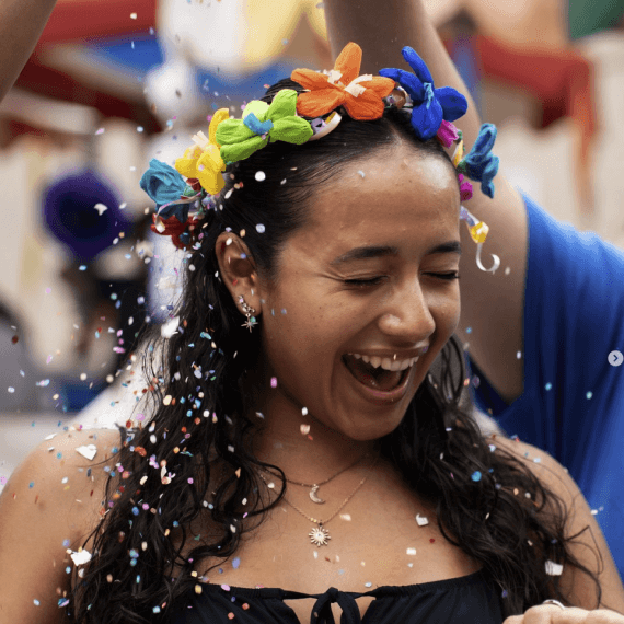 UTSA student smile while getting a fiesta cascaron on her head