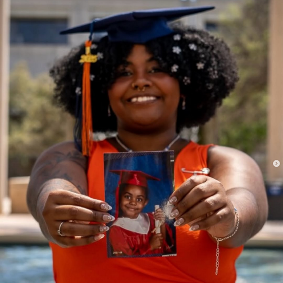 A graudate holding her photo in front of the camera.