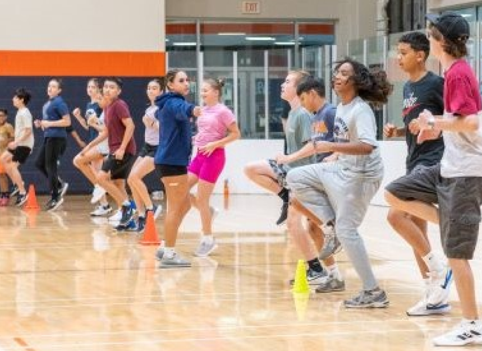 Young girl performing a squat while holding a weighted barbell