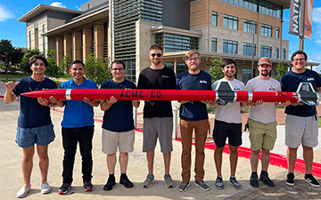 Students holding a red rocket