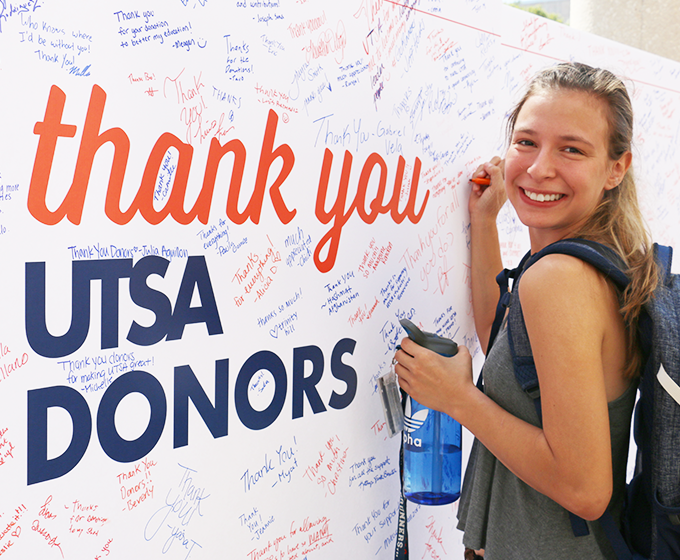 UTSA student writing on thank you letter