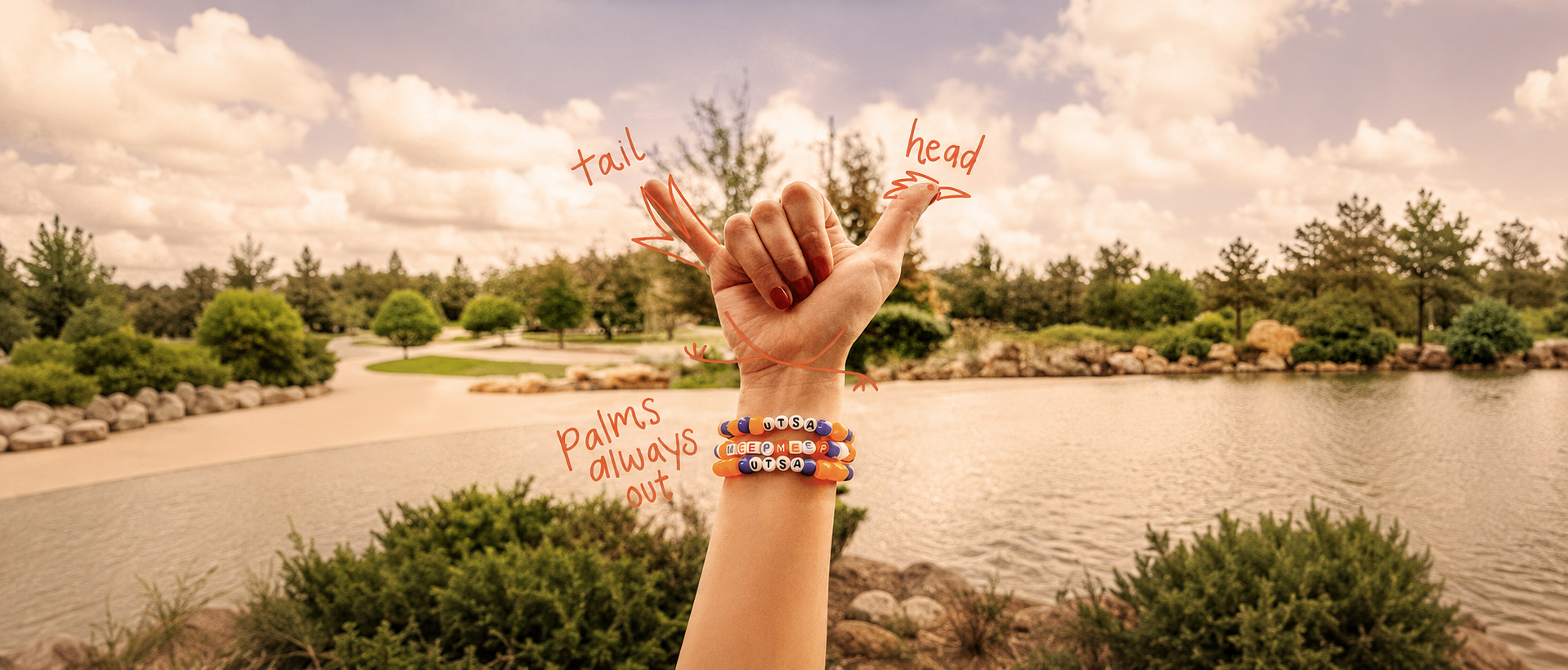 Girl's hand doing birds up by pond