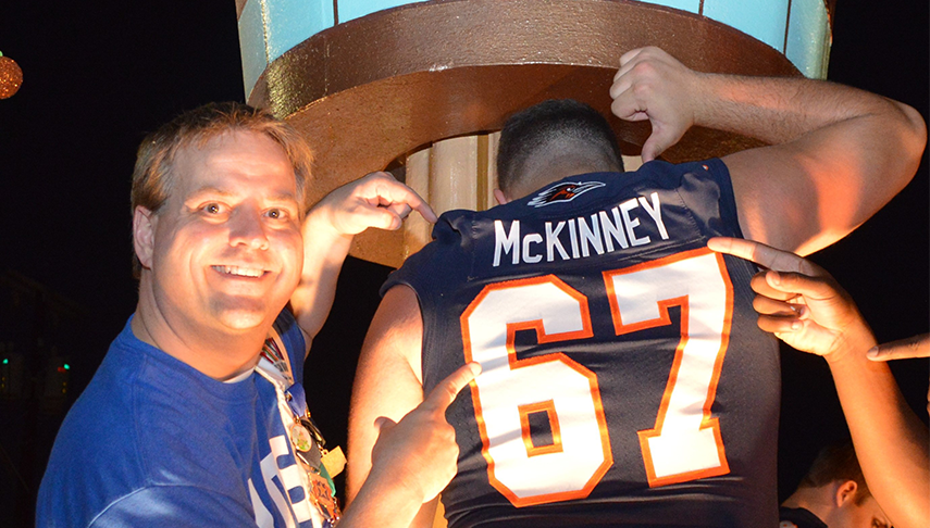 Barry McKinney pointing to UTSA football players jersey