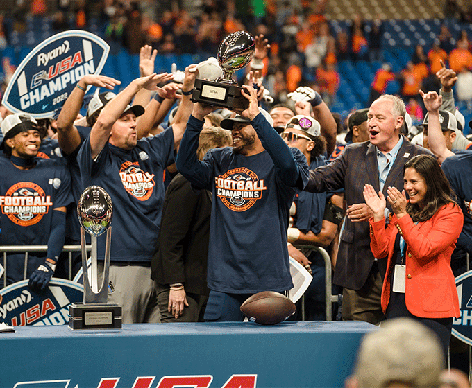 Quarterback Harris holding up trophy