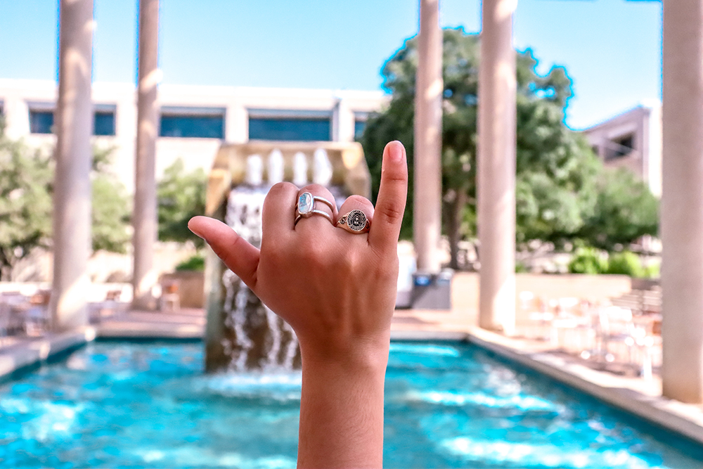 Student with UTSA ring giving birds up at Sombrilla Plaza