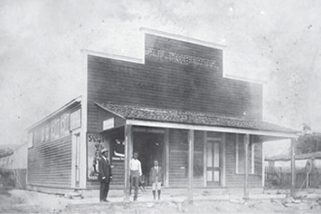 P.F. Roberts stands in front of his grocery store with family