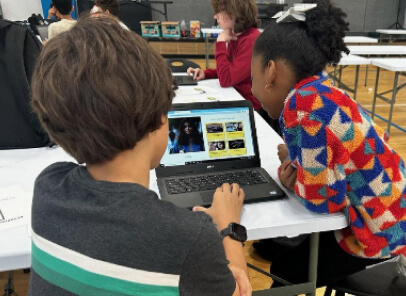 Two young children interacting with a laptop