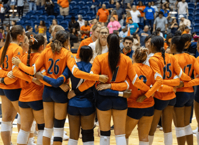 Volleyball team in a huddle during their game.