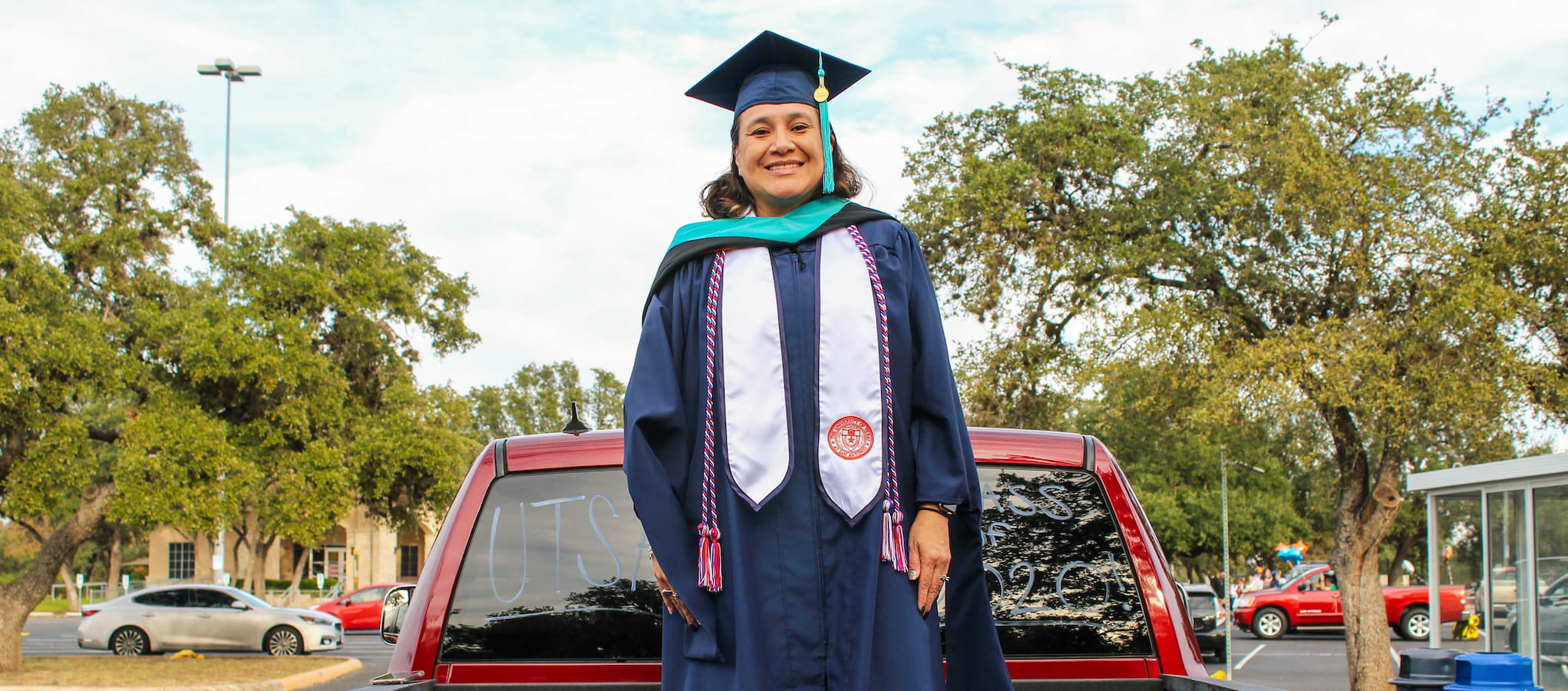 Commencement Drive student with full regalia on campus