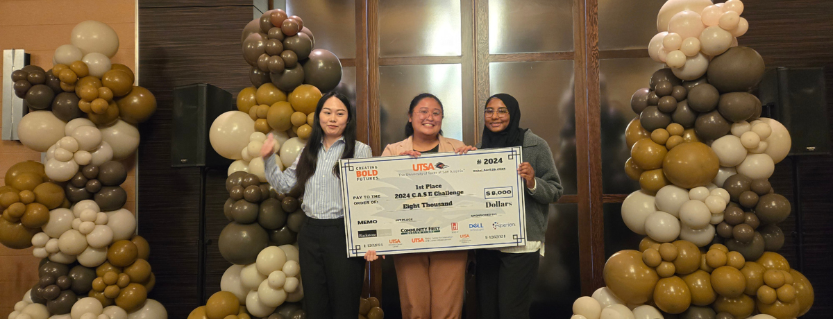 Students taking a photo with the check they won