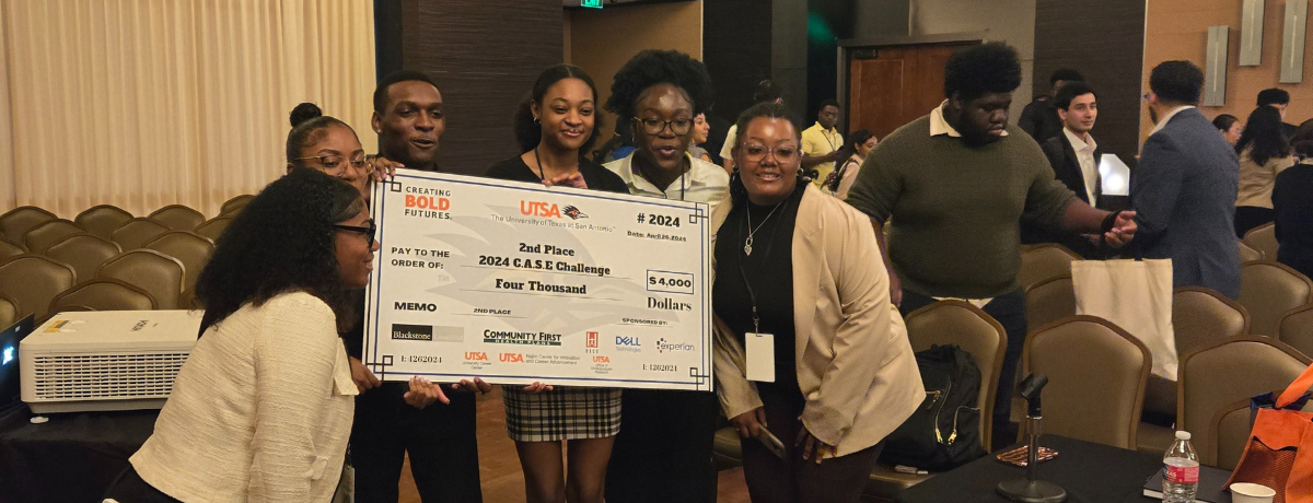 Students taking a photo with the check they won