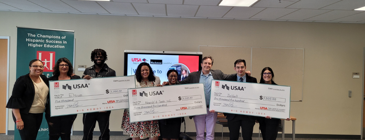 Students taking a photo with the check they won