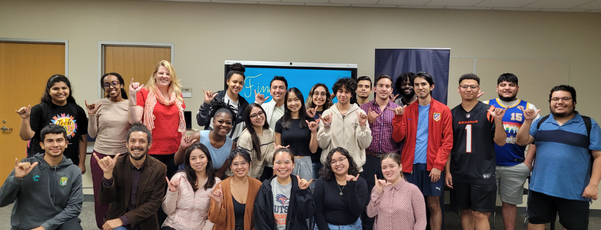 Group of students doing the roadrunner sign with their hands