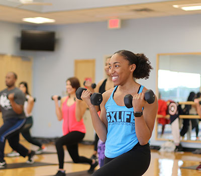 Student lifting weights in a group class