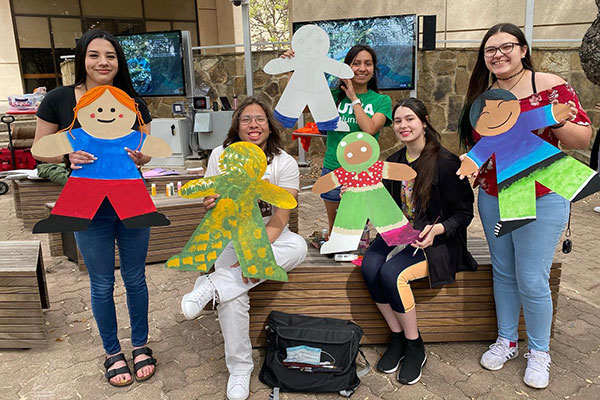 Group photo of students posing with cardboard cutouts of kids