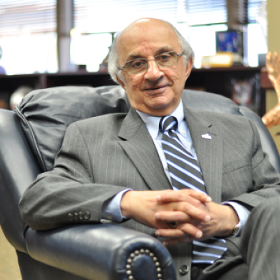 Harvey E. Najim sitting and smiling