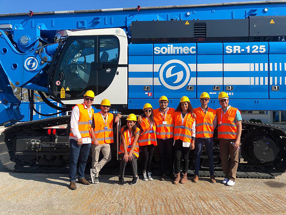 engineering students pose in front of a bulldozer