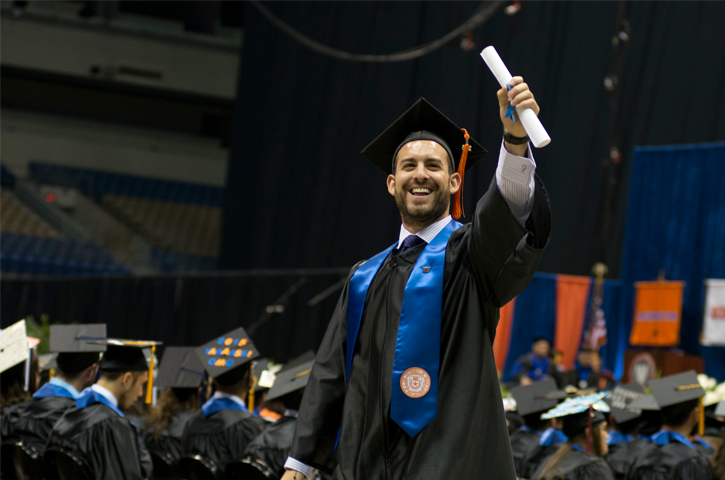 student holding a diploma