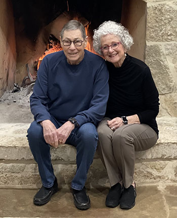  Louise and Michael Beldon smiling by fireplace