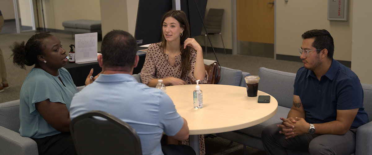 Team chatting at table before meeting