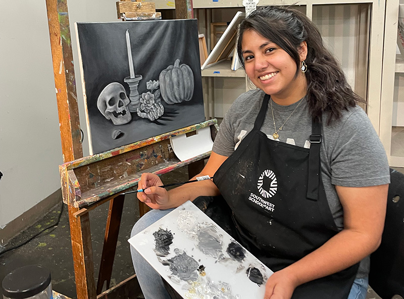 Nia Jaramillo painting on a canvas