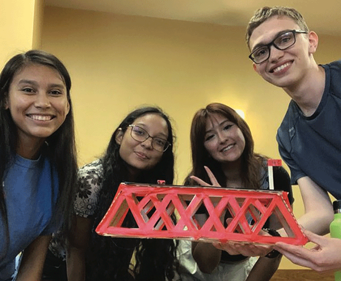 UTSA Students holding model bridge in hand