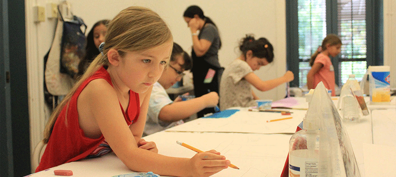 Little girl drawing at Young Artist Program