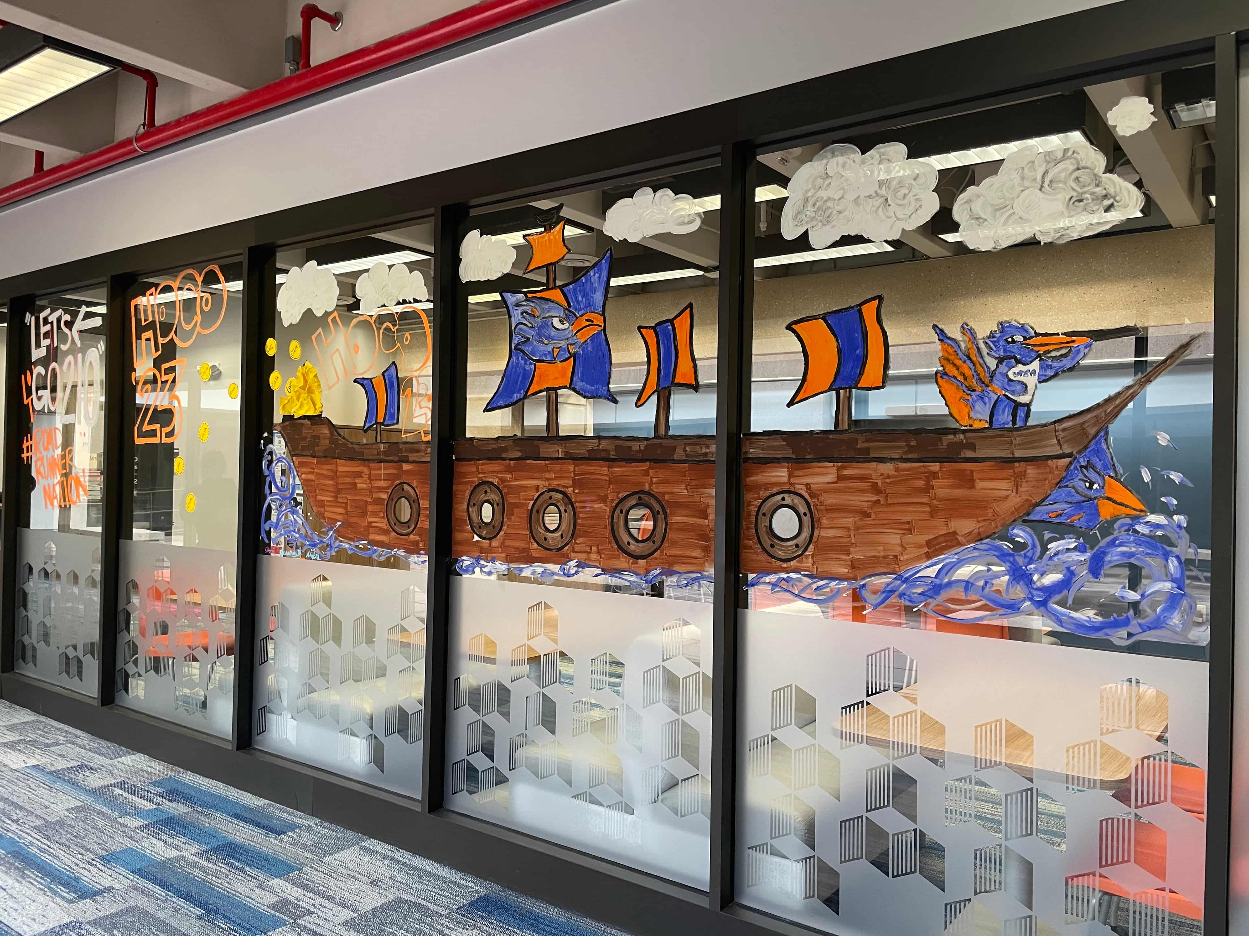 2023 Office Decorating Winner - large ship with blue and orange sails, a Roadrunner captain and clouds
