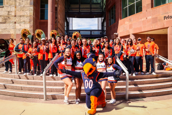 Band and cheer with Rwody in front of Frio Street building Downtown campus