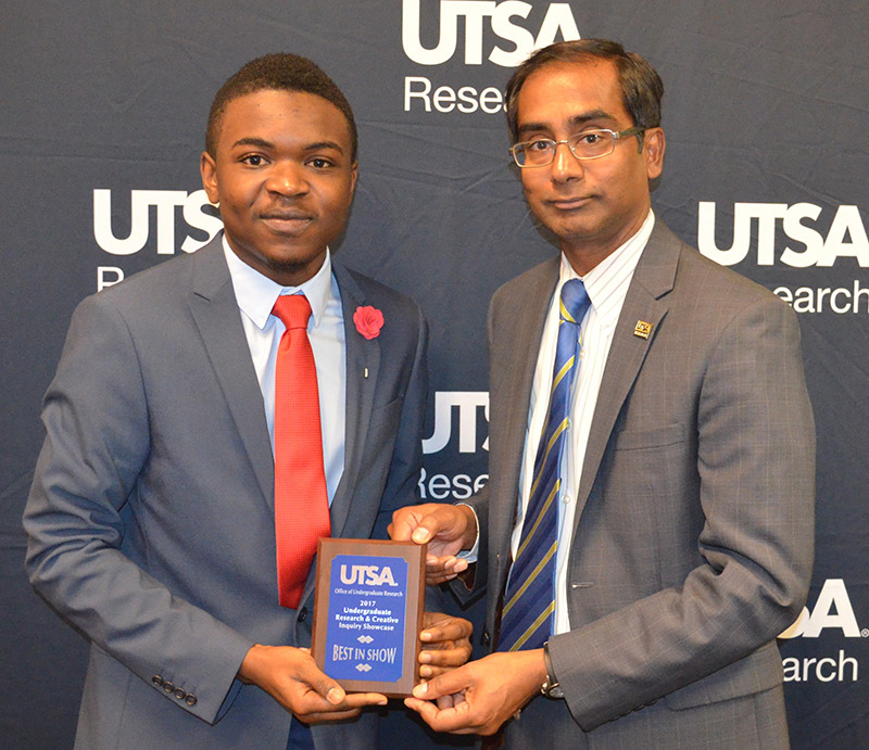 Electrical and computer engineering student Aires Ngunza receives his award from Interim Vice President for Research Bernard Arulanandam.