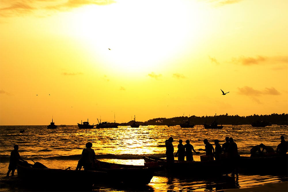 The sun prepares to set over fishing boats in Tarkarli, India.