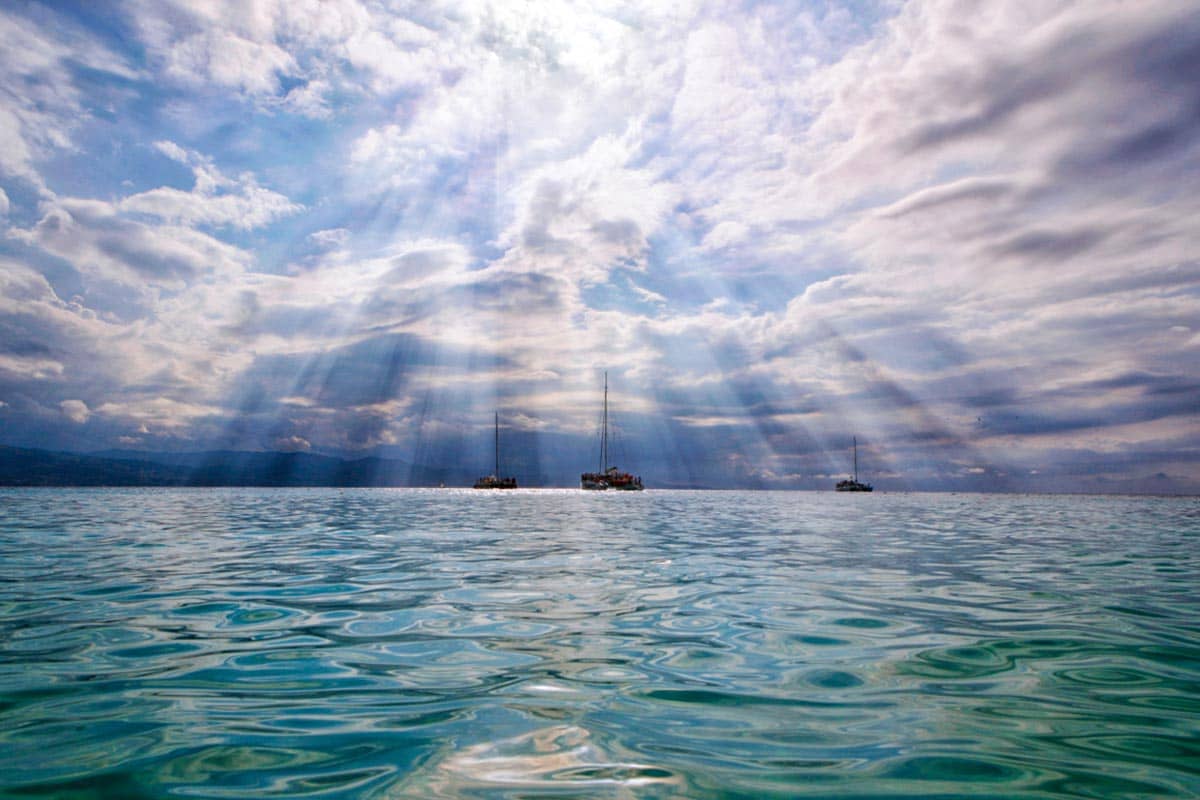 The bright Caribbean sun beams down on boats at sea.
