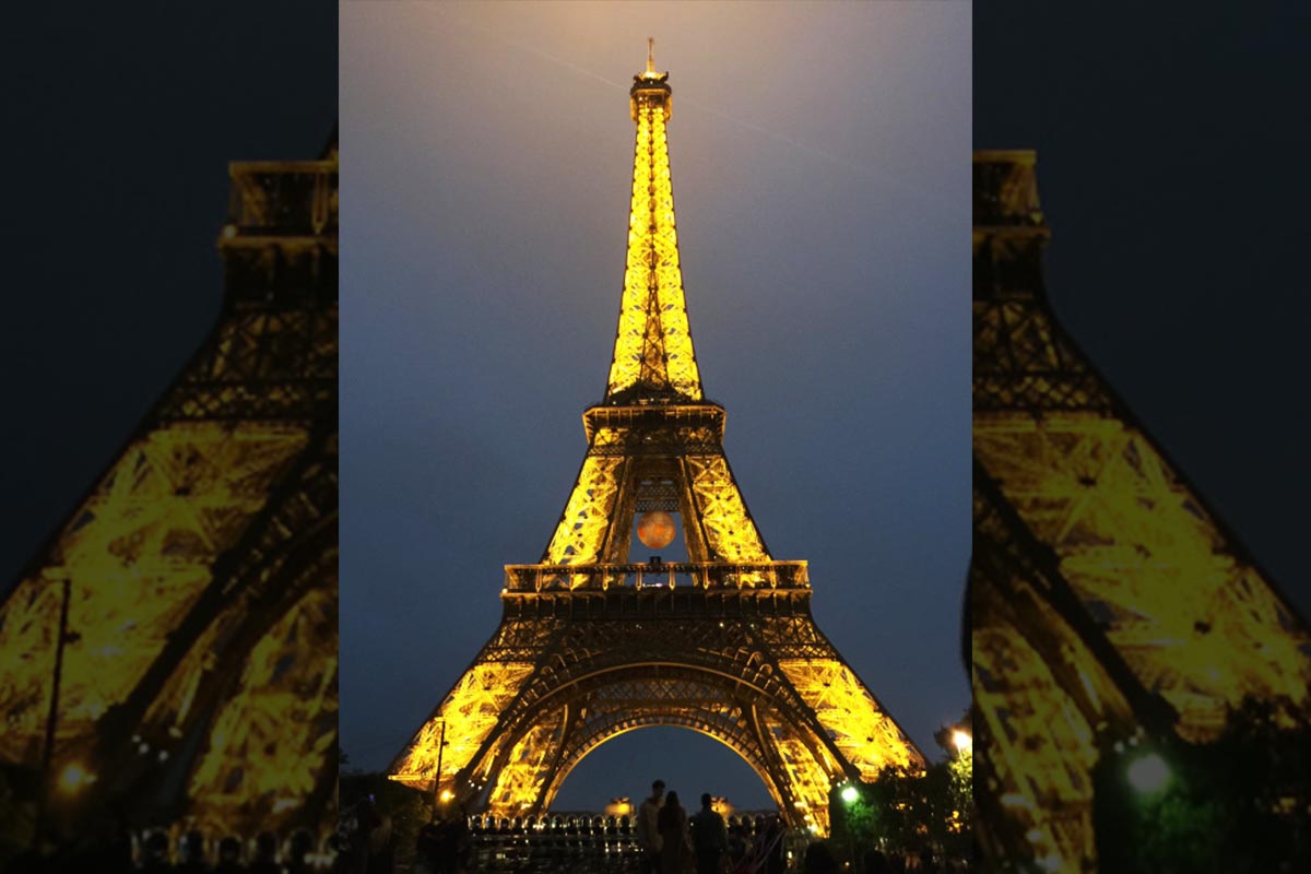 The Eiffel Tower, located in Paris, lit at night.