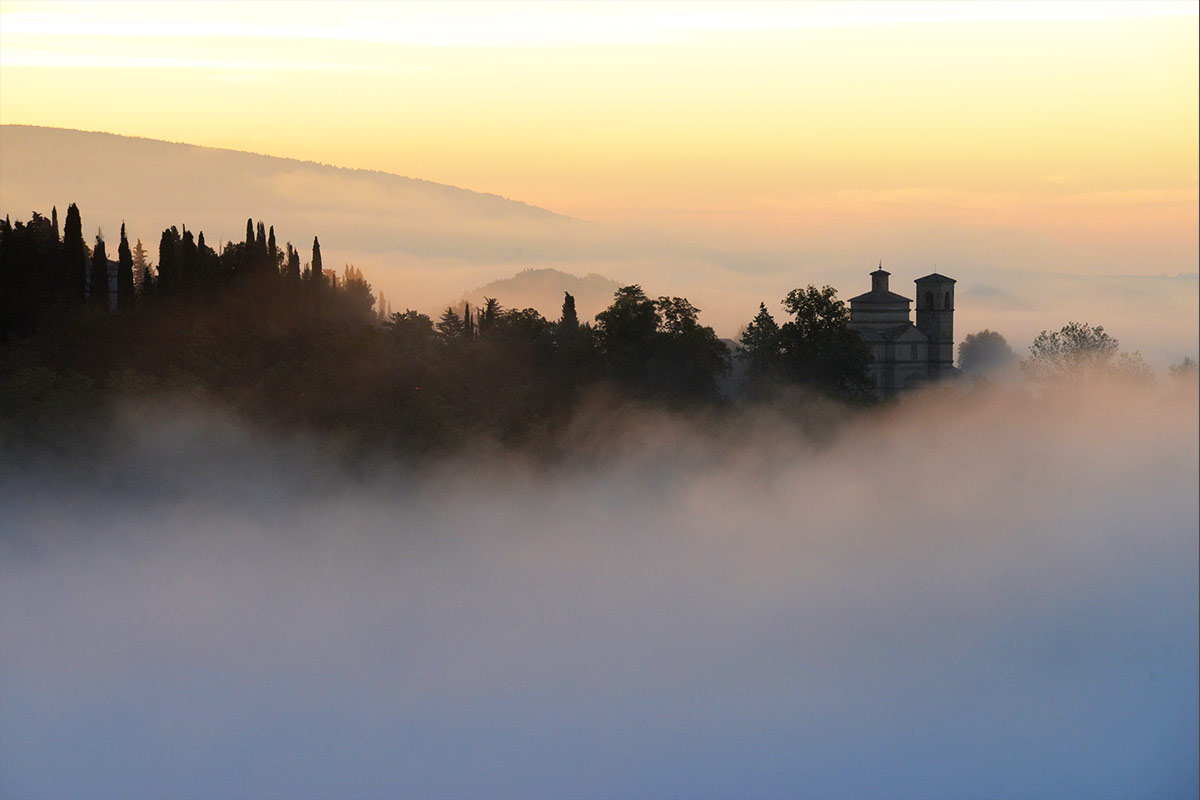 Fog hangs in the valleys between the hills the Tuscany town of Urbino, Italy.