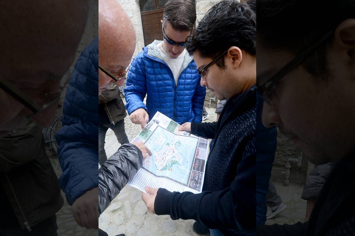 College of Engineering professor Arturo Montoya [right] uses a map of Urbino, Italy, to help students find their destination.