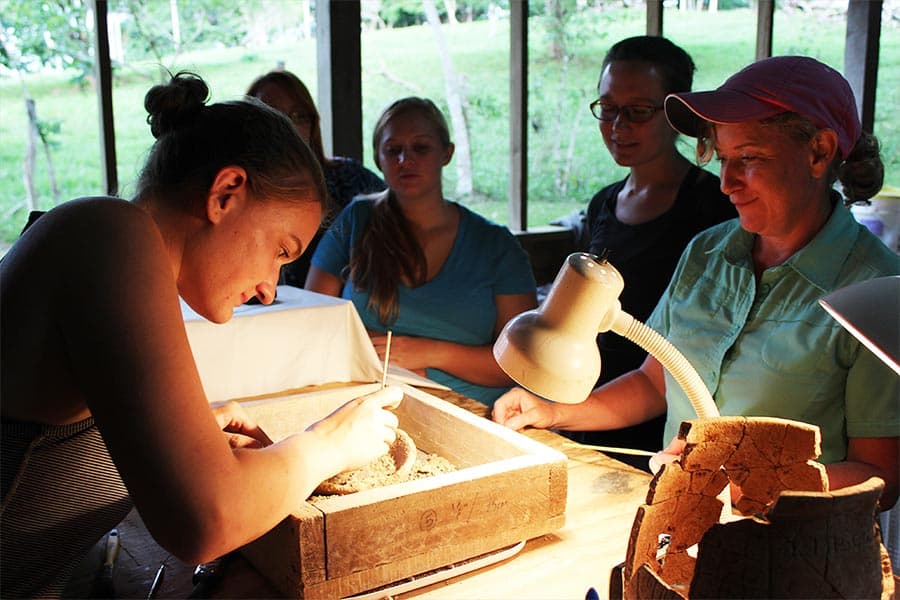 At the ancient Maya archaeological site of Xunantunich in Belize, UTSA anthropology doctoral student Zoe Rawski [left] and professor Kathryn Brown excavate some of the contents of a ceramic vessel cache that contained two jade effigies.