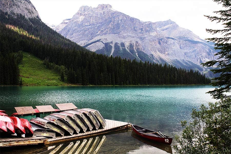 Boats and canoes await lazy rowers along the shore of Emerald Lake in Canada.